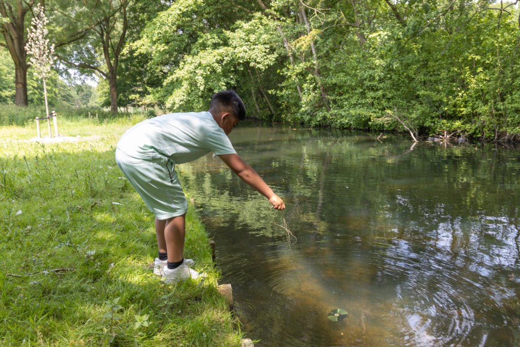 Jongetje onderzoekt het water in een singel