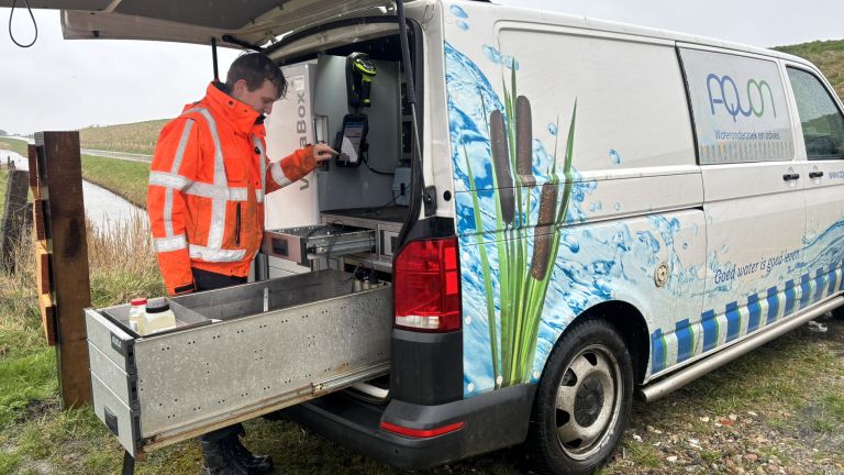 Medewerker van Aquon bij een meetwagen