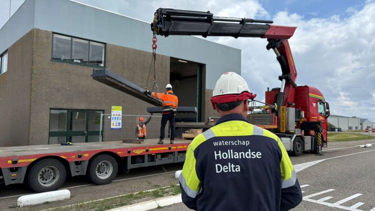 Een onderdeel van de spui-sluis wordt getakeld.