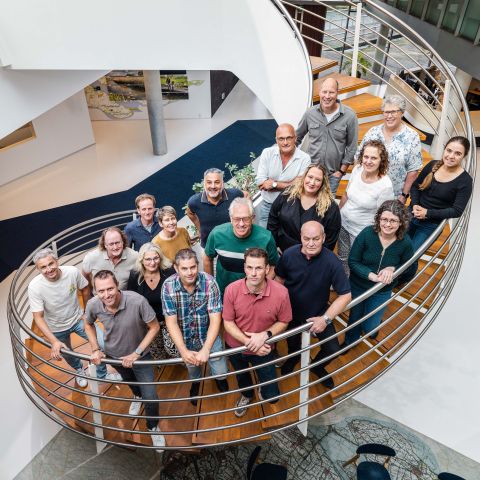De medewerkers van het Team Baggeren van waterschap Hollandse Delta op een trap in het waterschapshuis