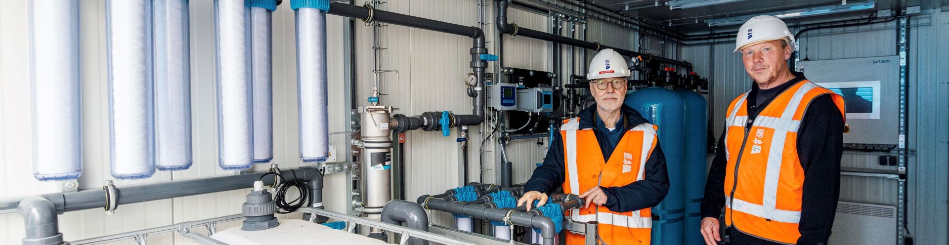 Heemraad Anne Mollema en procesoperator Rob Bakker inspecteren de container met de DEXSORB-filter installatie