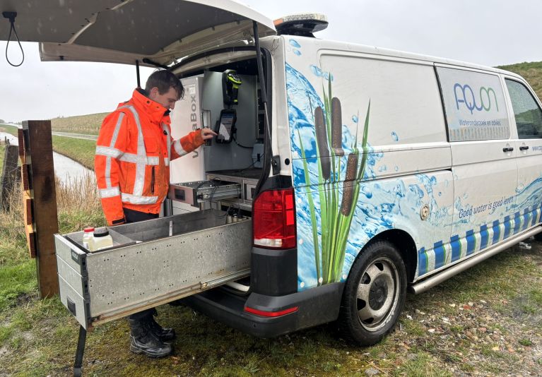 Medewerker van Aquon bij een meetwagen